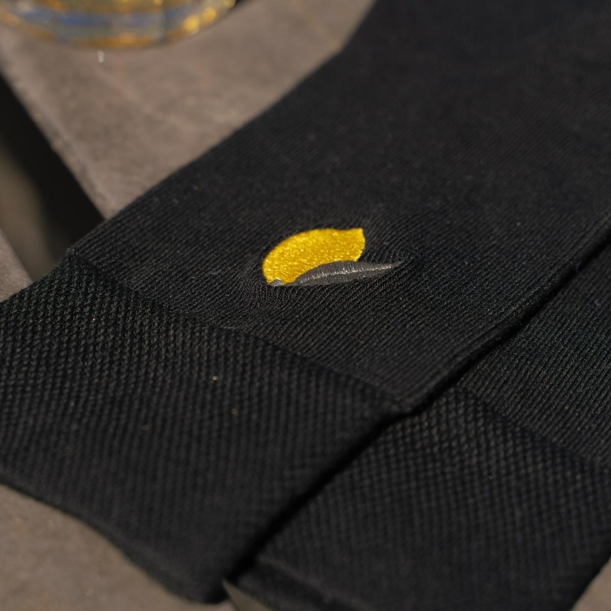 Macro close-up of yellow lemon embroidery on black Synix Limona sustainable sock