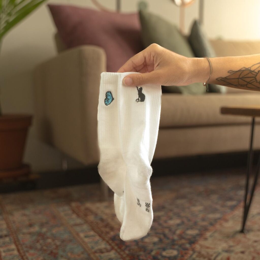 Synix DayDream sustainable socks in white with cat and butterfly embroidery indoors