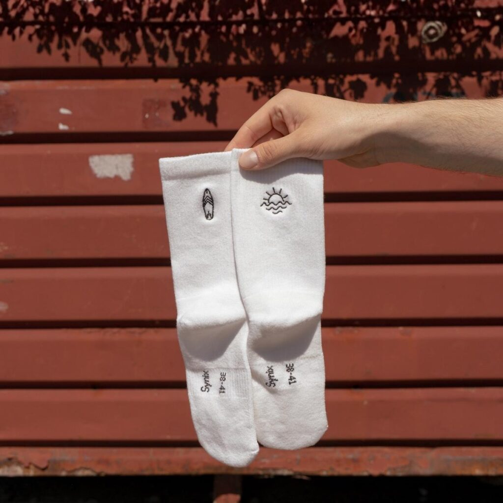 Synix SunSeeker sustainable socks in white with surfboard and ocean sun embroidery