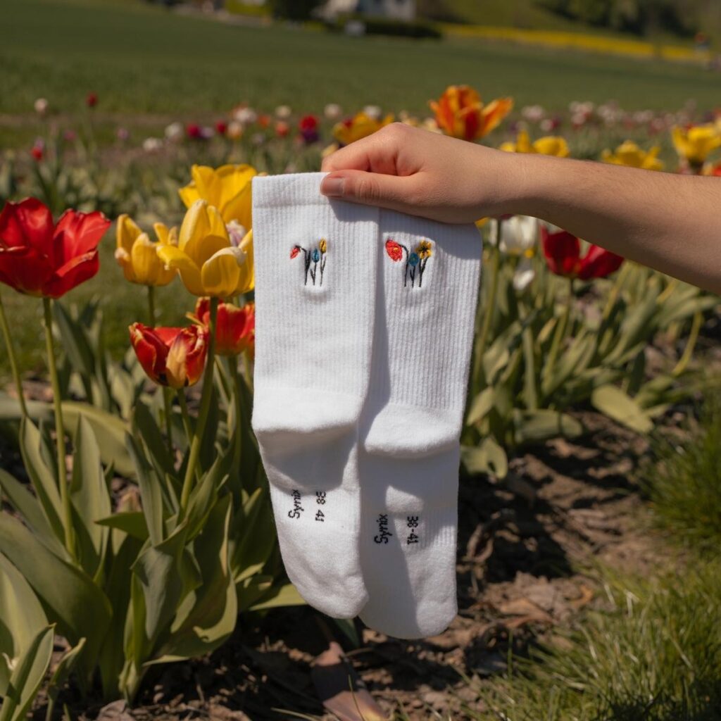 Synix UnFold sustainable socks in white with colorful tulip embroidery in tulip field